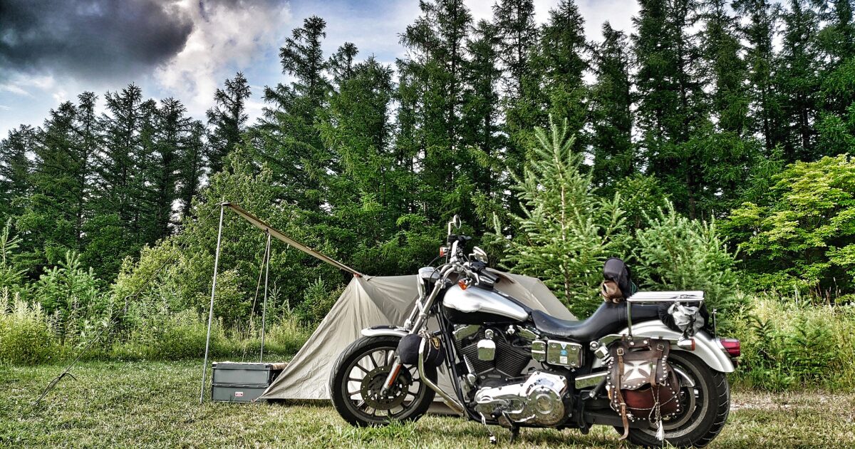 バイクとソロキャンプテントと森林の風景