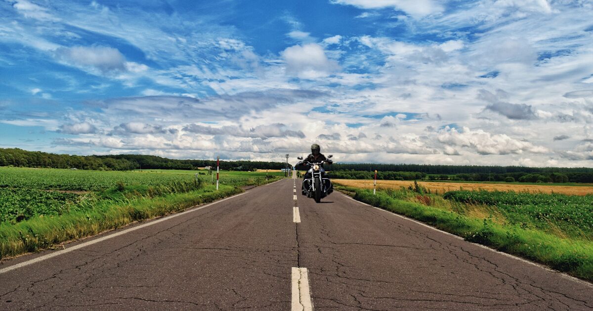 広大な農地の中を進むバイクとライダー
