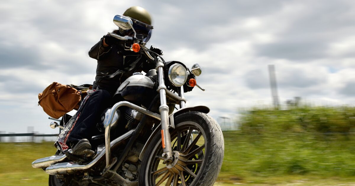 バイクでツーリング中のライダーと草原の風景