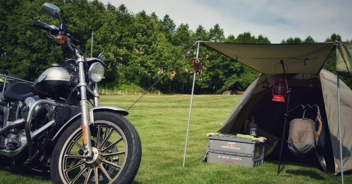 芝生のキャンプ場とテントとバイクのアウトドア風景