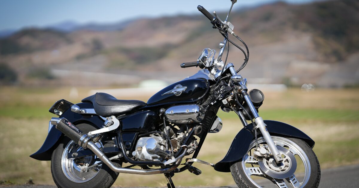 黒いクルーザーバイクと山並みの遠景