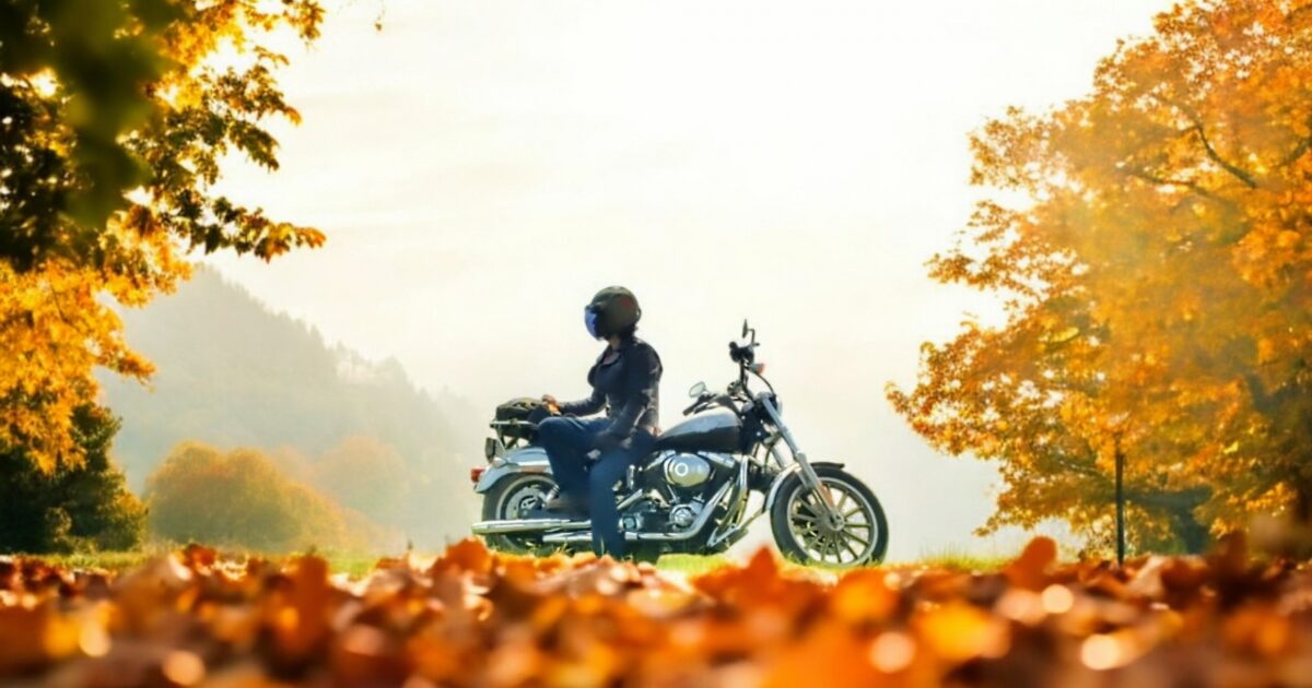 秋の紅葉とバイクにまたがるライダーの風景